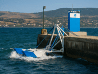Sistema de generación de energía por olas de Eco Wave Power conectado a un muelle, con olas visibles impactando la estructura flotante.