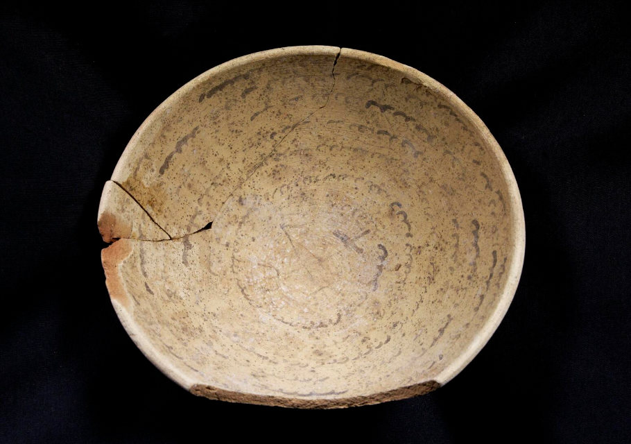 Cuenco de cerámica del siglo V con inscripción hebrea en espiral, parcialmente restaurado, fotografiado sobre fondo negro. Conservado por la Autoridad de Antigüedades de Israel.